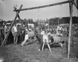 men climbing into hanging barrels
