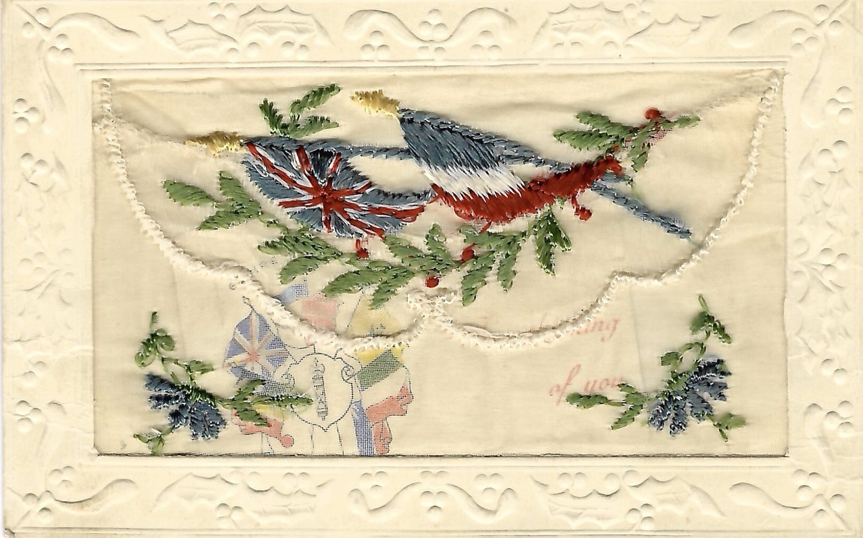 Mail card with fabric stitching of Allied European flags on poles surrounding an anchor. Below is written “Greetings France.”