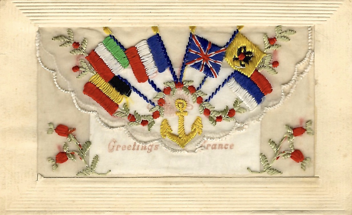 Mail card with painted illustration of, from clockwise, flags of France, Russia, Italy, Serbia, Japan, Belgium, United Kingdom, surrounding a coat of arms. “I’m Thinking of you” is written in cursive to the right.