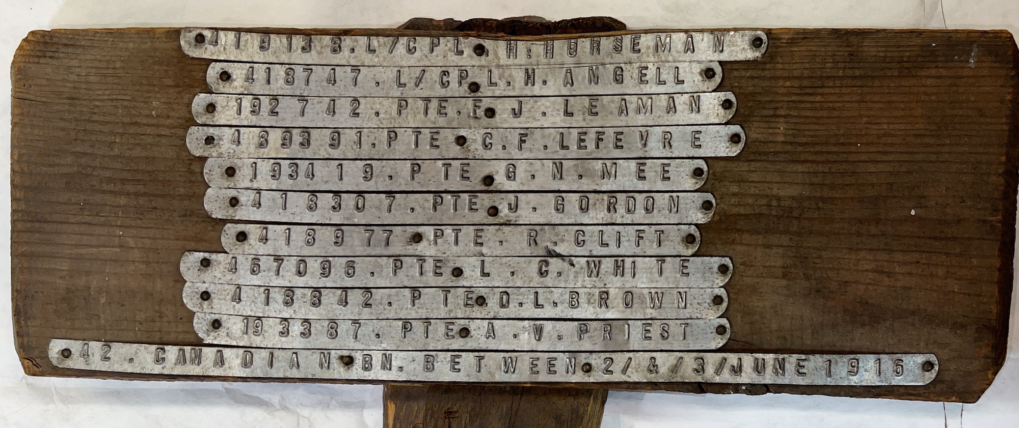 Grave post with names of deceased servicemen and battalion inscribed on metal strippings