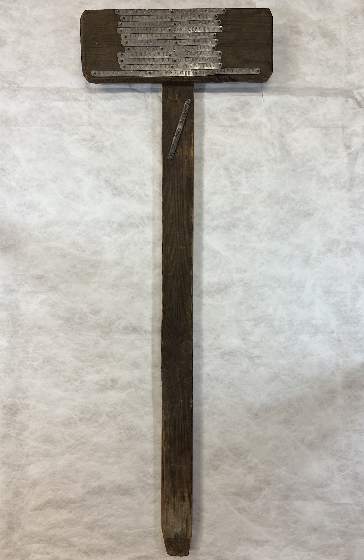 Grave post with names of deceased servicemen and battalion inscribed on metal strippings