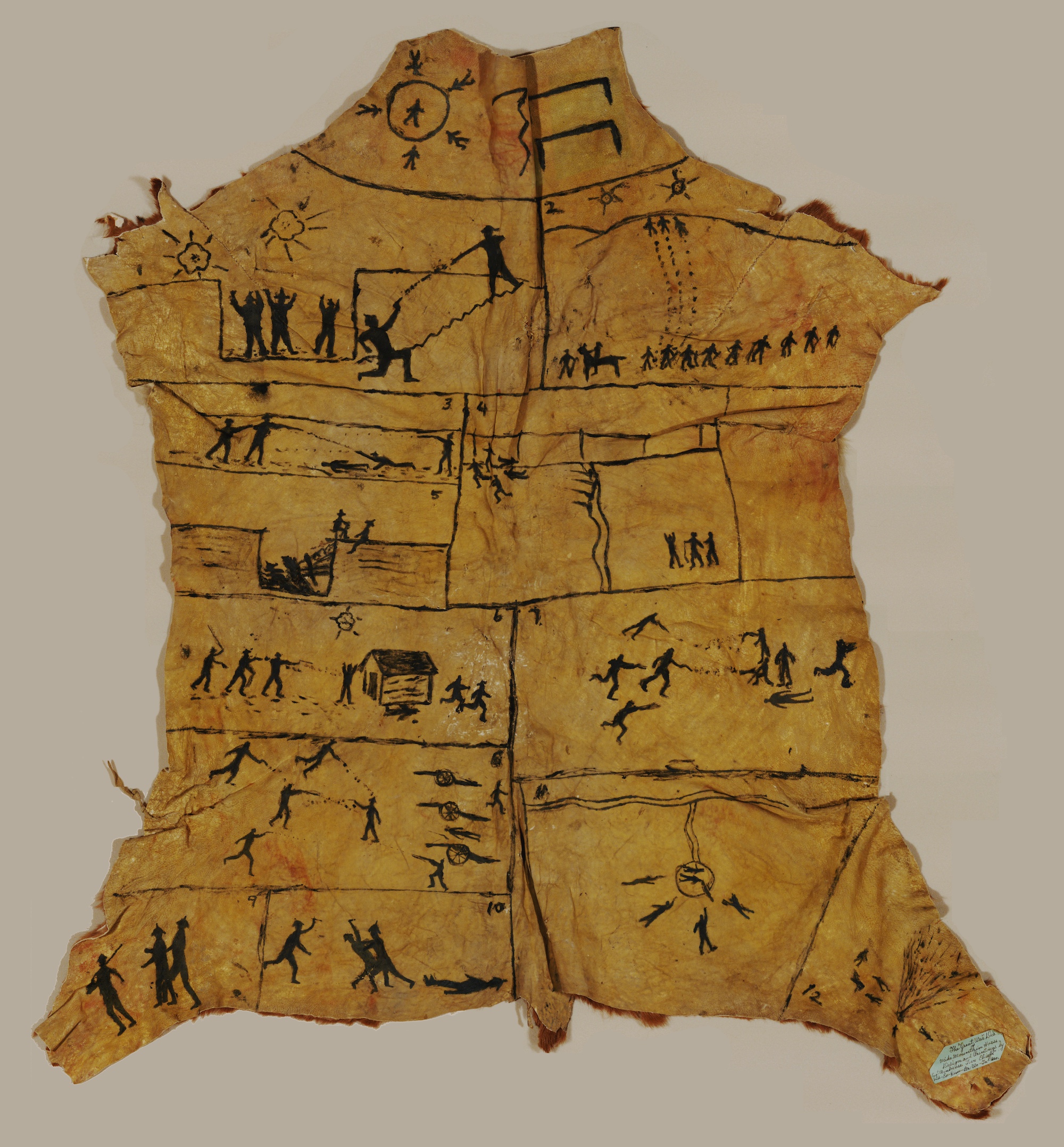 Animal hide with illustrations on it, is splayed onto white background, depicting stick-figures reenacting various combat scenes.